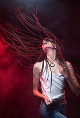 Emotional photo of a beautiful slim girl with creative make-up and a hairstyle of cornrows, wearing...