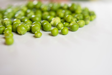 Fresh green appetizing peas on a white background.