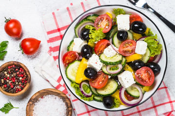Greek salad in black plate on the table.