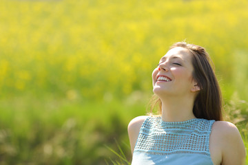 Happy woman resting breathing fresh air in a field