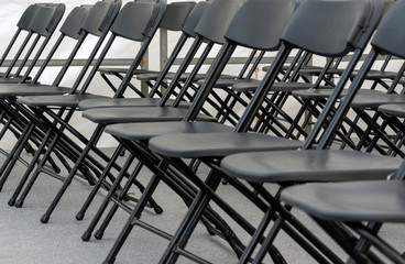 numerous folding chairs arranged in a row