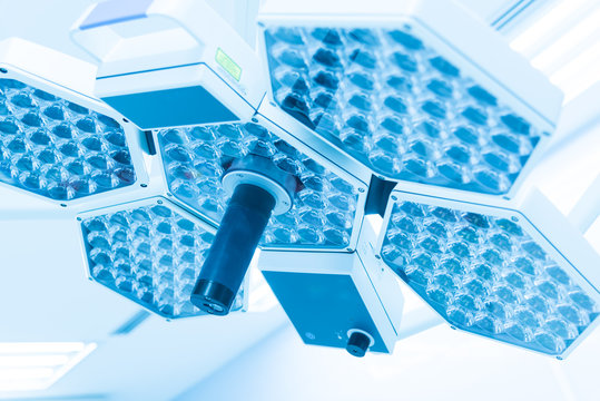 Surgical lamps in operating room and modern equipment at hospital.Medical device for surgeon surgical emergency patient in blue tone style.Save life medical treatment concept.