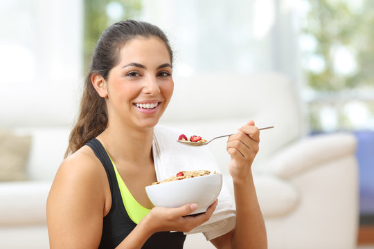Sportswoman posing with cereals after sport at home