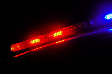 Strobelight bar on top of police car flashing red and blue.