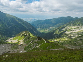 View from Smutne sedlo on mountain valley Smutna dolina with rock boulders, footpath trail, dwarf scrub pine and green mountain peaks. Western Tatras mountains, Rohace Slovakia, summer, blue sky © Kristyna