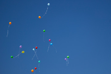 Balloons in the sky. Festive balloons fly through the air. Many balloons filled with helium and released up. Festive background.