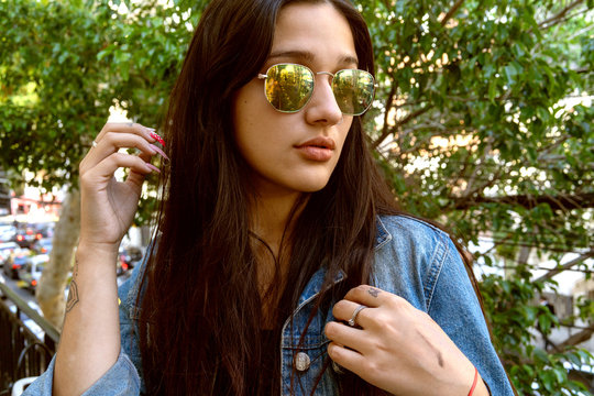 Young girl, playing to be a model in the city, in different options with her sunglasses