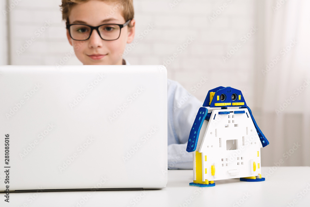 Poster Smart boy constructing robotic toy and using laptop