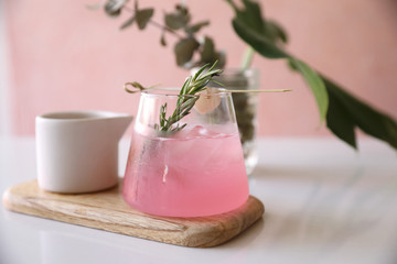 Pink cocktail with rosemary and lychee in pink background