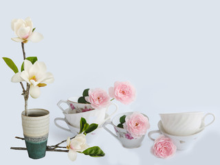 Blooming magnolia fkiwer vase wuth coffee cup.