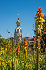 Tour Lu in Nantes on a Sunny Summer Day with Green Vegetation and Orange Common Torch Lilly Flowers