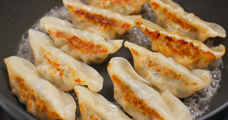 Fry Chinese meat dumpling in pan
