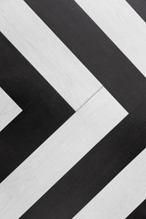 top view of black and white wooden herringbone floor background texture, Looks like direction arrow symbol.