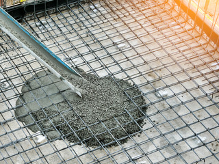 Pouring ready-mixed concrete after placing steel reinforcement to make the road by mixing mobile...