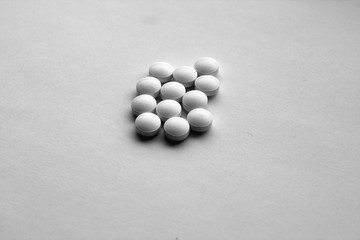 Fototapeta na wymiar White pills on white with blur effect in black and white.