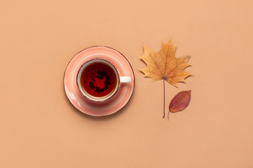 Autumn Flat lay composition. Cup of tea, autumn dry bright leaves, roses flowers, orange circle,...