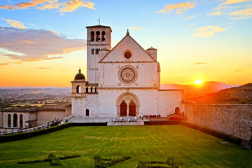 Basilica of San Francis of Assisi with beautiful setting sun behind, Italy