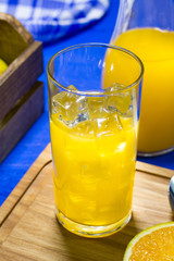 Copo Americano com Suco de laranja sobre a mesa de madeira azul.