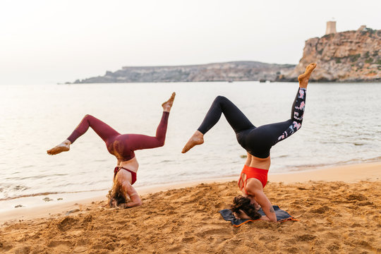Young women doing yoga on beach