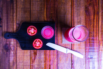 Suco de tomate natural sobre a mesa de madeira com fundo preto