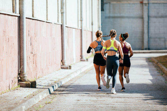 Rear view of women running outdoors
