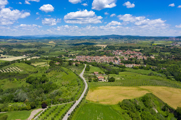 Fototapeta na wymiar Rolling hills of Tuscany, Italy, on a sunny summers day. A paved road runs through the country landscape.