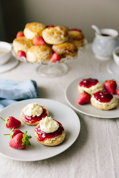 Cornish and Devonshire style scones with jam and cream opposite