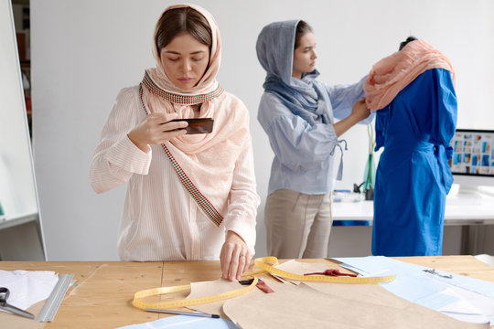 Women designing conservative clothes in atelier