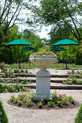 The tall flower pot in the garden of the park on a sunny day.