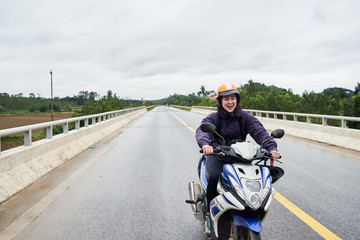 Scared and happy girl learning how to drive a motorbike.