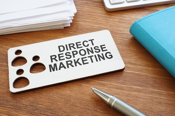 Direct response marketing sign and stack of papers.