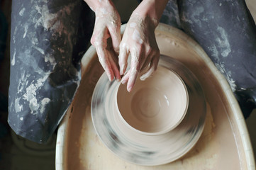 Crop hands making pottery