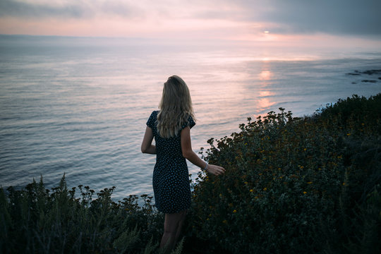 Teen girl on a bluff overlooking the ocean