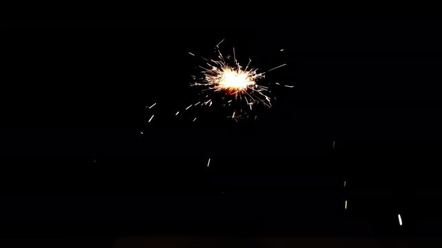 Slowed down video of burning sparkler in dark. Fiery bengal light on black background in 4k ultrahd (UHD) 3840x2160