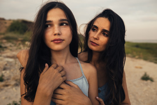 Close up of mother and daughter standing on beach