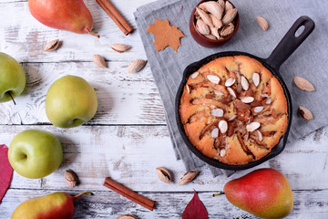 Pie with pears, apples and almonds in a little cast iron pan. Top view