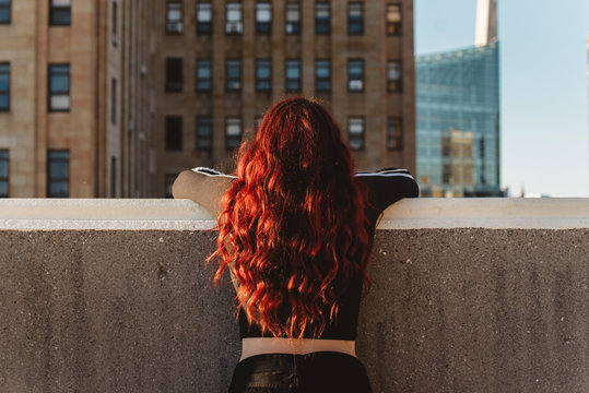 A teenage girl watching the sunset in the city