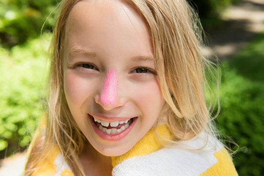 Girl with pink zinc oxide on her nose