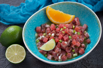 Tuna ceviche cooked with lime and orange juice and served in a turquoise plate, horizontal shot