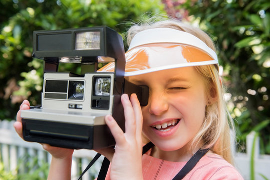 Girl taking photo with polaroid camera