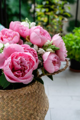 Bouquet of beautiful pink peonies in straw basket