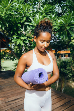 Black woman carrying yoga mat