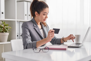 Young woman entering credit card credentials for online purchase