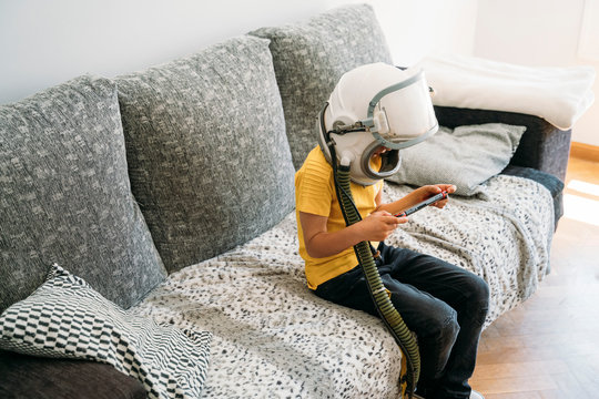 Boy Wearing Space Hat While Playing Video Game On Games Console