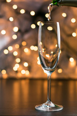 Copa de champaña con fondo negro y bokeh dorado y azul.