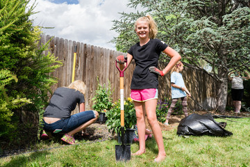 Young girls with garden hose in backyard