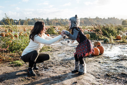 Asian Mother and Daughter Pumpkin Patch During Fall Season