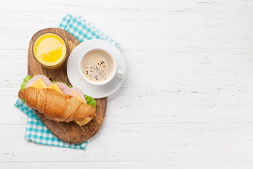 Coffee, orange juice and croissant sandwich