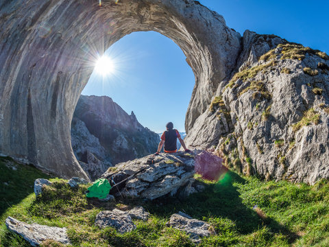 Spain, Asturia, Pena Mea, Ojo de buey, hiker sitting on rock
