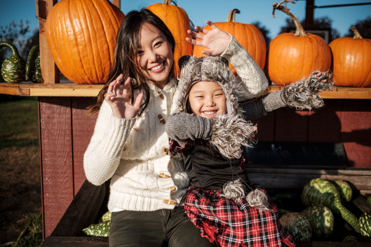 Asian Mother and Daughter Pumpkin Patch During Fall Season